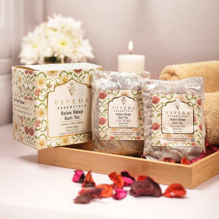 Viveda Essentials tea packaging on a wooden tray with flowers and candle in the background